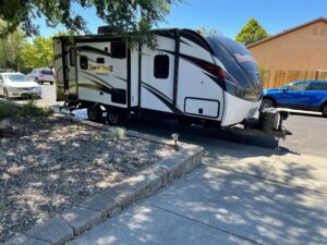 A white and black trailer parked on the side of a road.