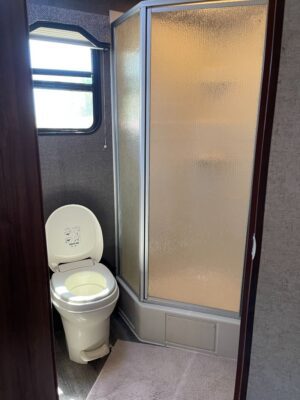 A toilet and shower in a small bathroom.