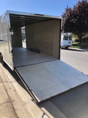 A truck with the back door open and a ramp on it.
