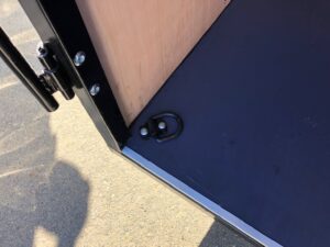 A close up of the door on a blue and black trailer.