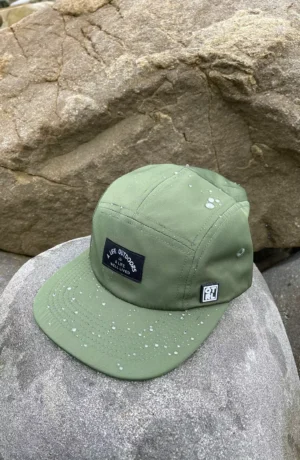 A green hat sitting on top of a rock.