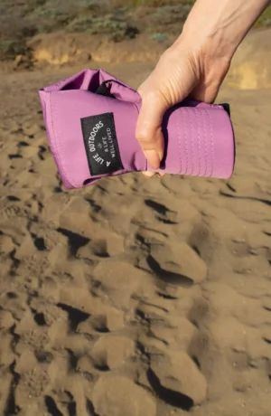 A person holding onto a purple yoga mat