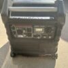 A black and silver generator sitting on top of the ground.
