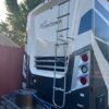A ladder is attached to the back of a rv.