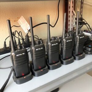 A row of walkie talkies sitting on top of a table.
