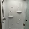 A white door with two shelves on the side of it.