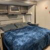 A bed with blue blanket and pillows in a room.