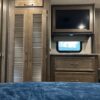 A bed room with a tv and a cabinet