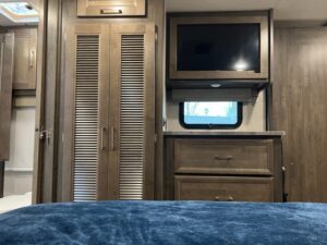 A bed room with a tv and a cabinet