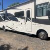 A white rv parked on top of gravel.
