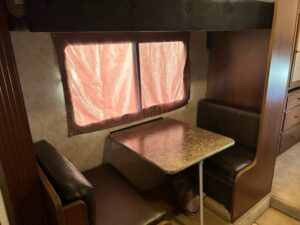 A table and chairs in the corner of an rv.