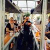 A group of people sitting on top of a bus.