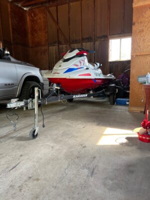 A car and a boat in a garage.