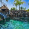 A pool with a slide and waterfall in it