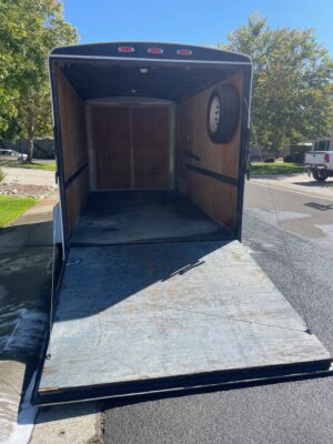 A trailer with a door open on the street.