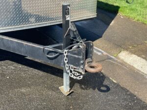 A black trailer with chains attached to it