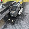 A black truck with a large piece of metal on it's side.