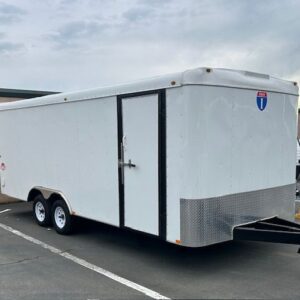 A white trailer with black trim parked in the parking lot.