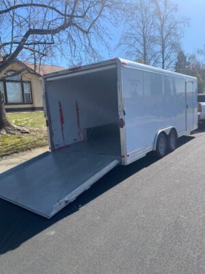 A white trailer with a ramp on the back of it.