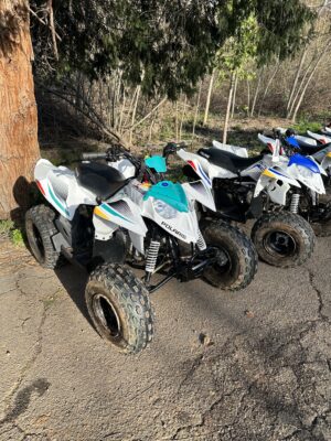 A group of four atv 's parked next to each other.